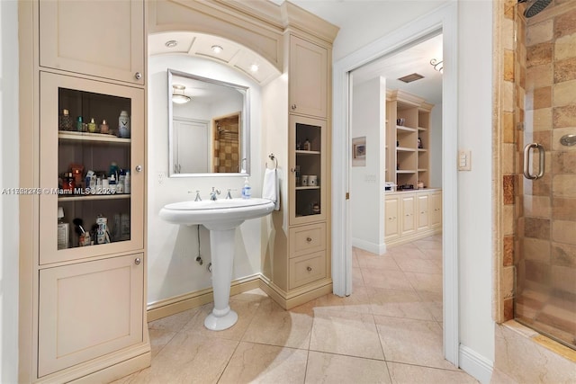 bathroom with a shower with door and tile patterned flooring