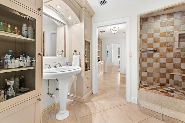 bathroom featuring built in shelves, tile patterned floors, and sink