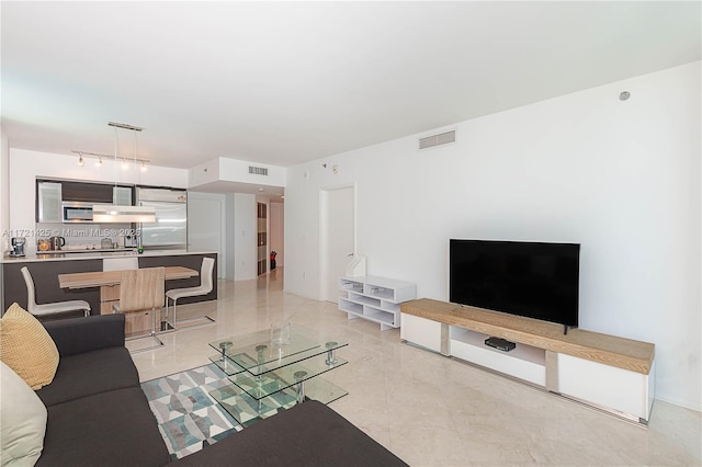 living room featuring rail lighting and visible vents