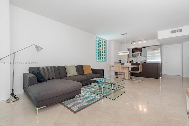 living area featuring rail lighting and visible vents