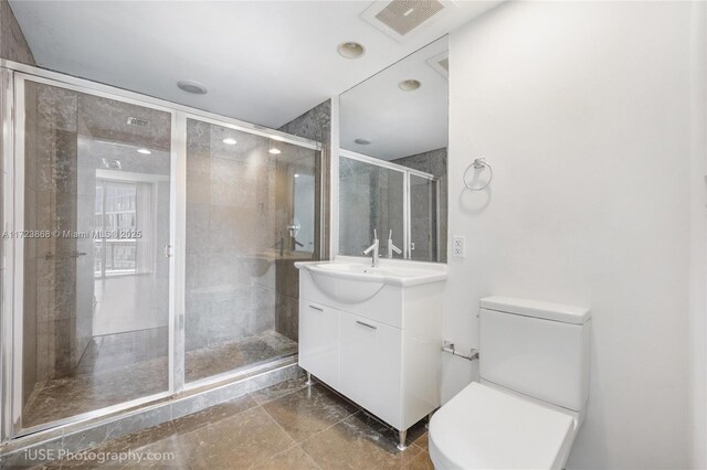 bathroom featuring toilet, vanity, and walk in shower