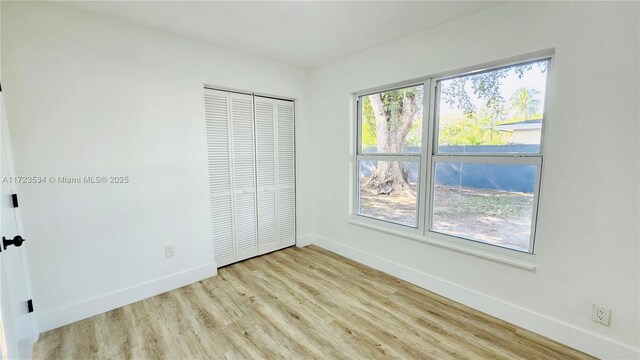 unfurnished bedroom with light hardwood / wood-style flooring and a closet