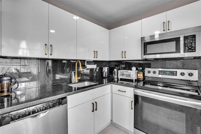 kitchen featuring stainless steel appliances, white cabinets, sink, and tasteful backsplash