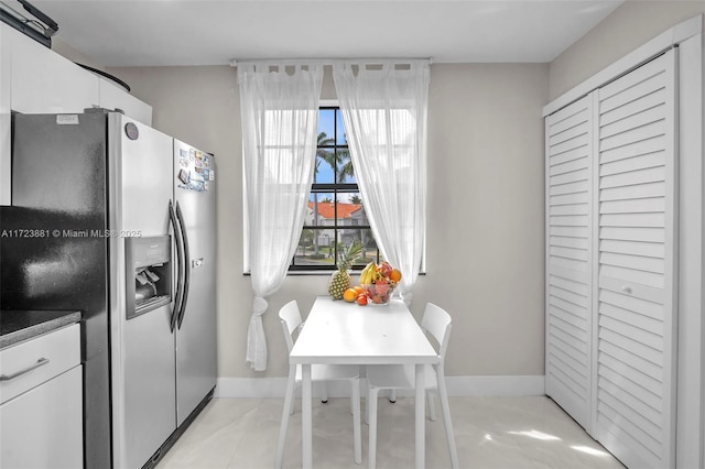 kitchen with white cabinets and stainless steel fridge with ice dispenser