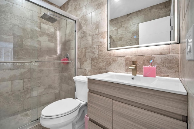 bathroom with tile walls, tasteful backsplash, toilet, a shower with door, and vanity