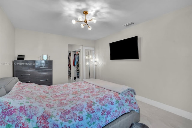 bedroom featuring a spacious closet, a closet, and a chandelier