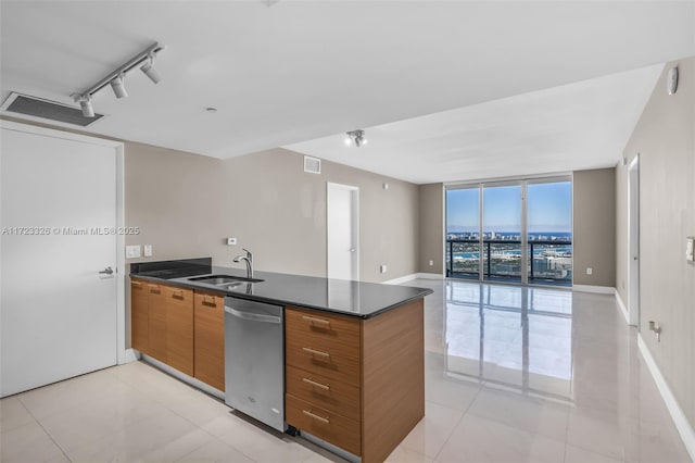 kitchen featuring dishwasher, expansive windows, rail lighting, sink, and light tile patterned flooring