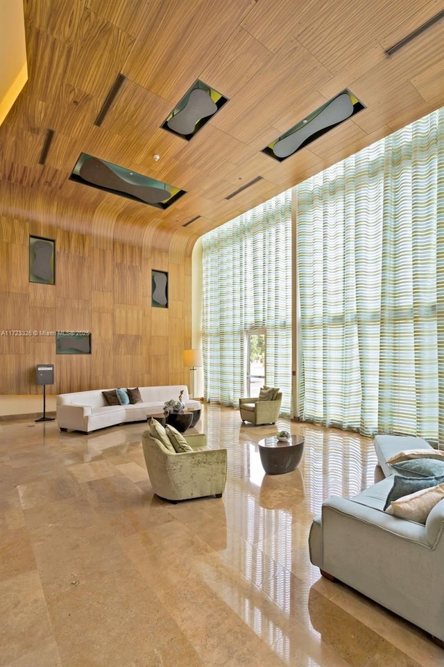 living room featuring wood walls, a wall of windows, and wooden ceiling