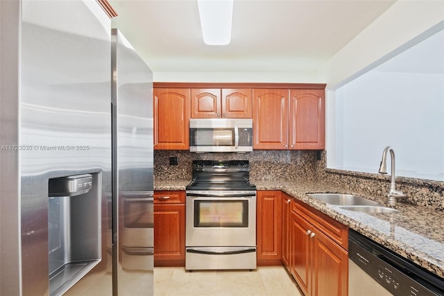 kitchen featuring appliances with stainless steel finishes, sink, backsplash, light tile patterned floors, and light stone counters