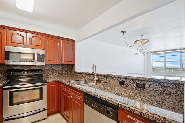 kitchen with tasteful backsplash, sink, a chandelier, dark stone counters, and stainless steel appliances