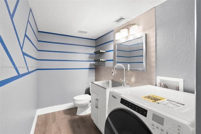 interior space featuring washer / dryer, a textured ceiling, dark hardwood / wood-style floors, and sink