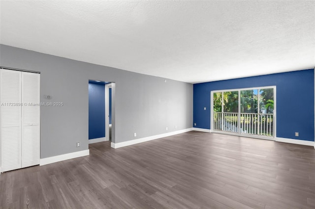 unfurnished living room featuring a textured ceiling and dark wood-type flooring