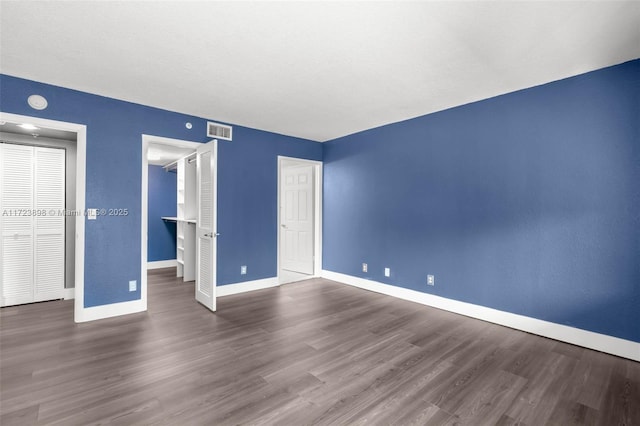 unfurnished bedroom with dark wood-type flooring