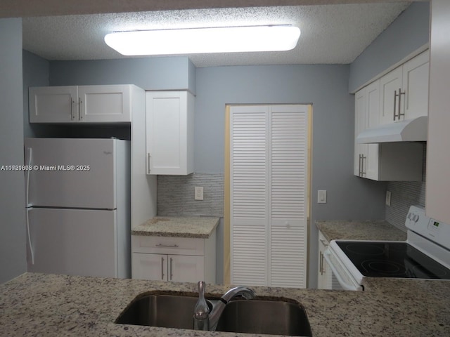 kitchen featuring backsplash, a textured ceiling, white appliances, sink, and white cabinetry