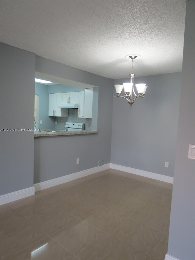 spare room featuring tile patterned flooring, a textured ceiling, and a notable chandelier