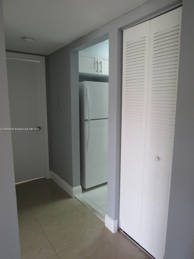 hallway with tile patterned flooring