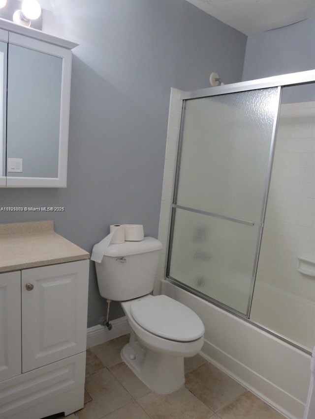 full bathroom with tile patterned flooring, vanity, toilet, and bath / shower combo with glass door