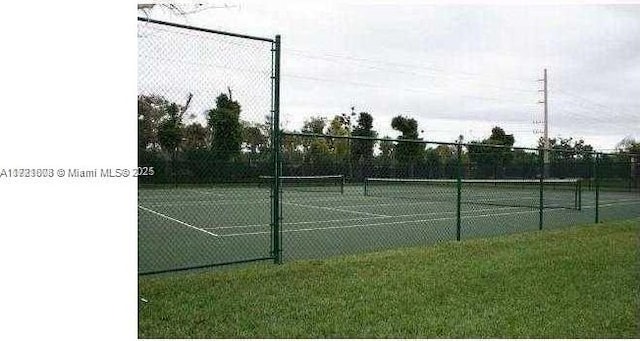 view of sport court with a yard