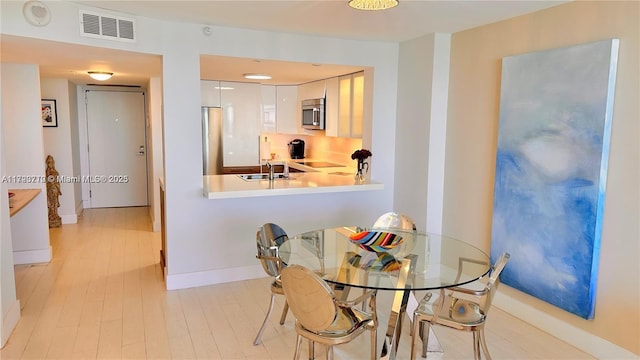 dining room featuring light wood-type flooring and sink