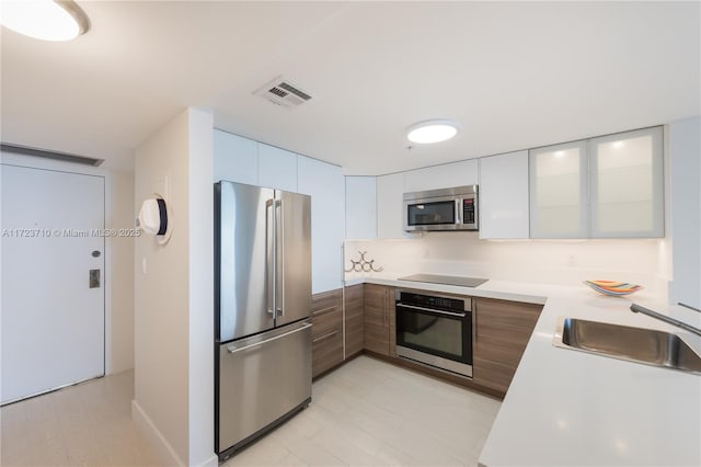 kitchen with sink, stainless steel appliances, and white cabinetry