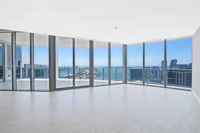 tiled empty room with floor to ceiling windows and a water view