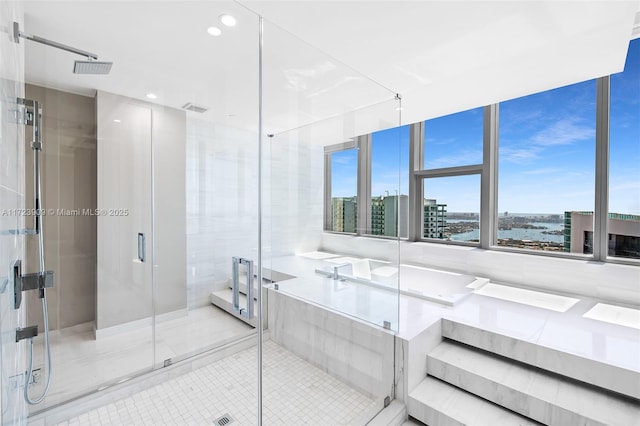 bathroom with tile patterned flooring, a water view, and a shower with door