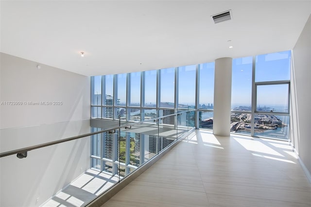 hallway with expansive windows and a water view