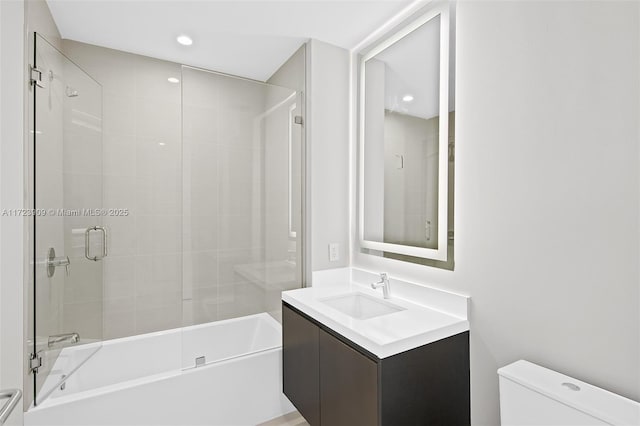 full bathroom featuring shower / bath combination with glass door, vanity, and toilet