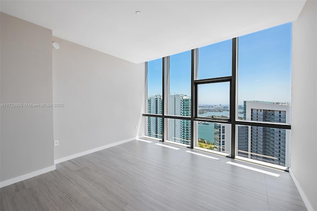 spare room featuring floor to ceiling windows and a water view