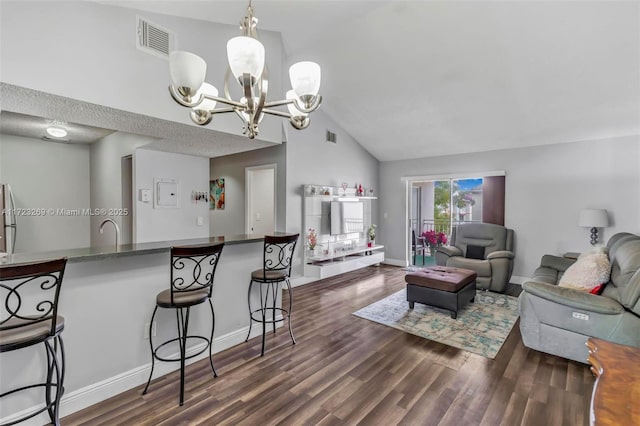 living room featuring vaulted ceiling, sink, dark wood-type flooring, and a chandelier