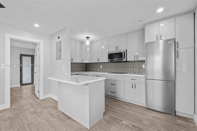 kitchen with appliances with stainless steel finishes, white cabinetry, sink, light stone counters, and electric panel