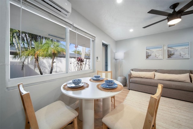 dining room featuring a wall mounted AC, hardwood / wood-style flooring, and ceiling fan