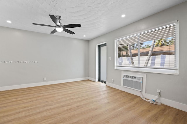 unfurnished room featuring a textured ceiling, ceiling fan, light hardwood / wood-style floors, and a wall mounted air conditioner