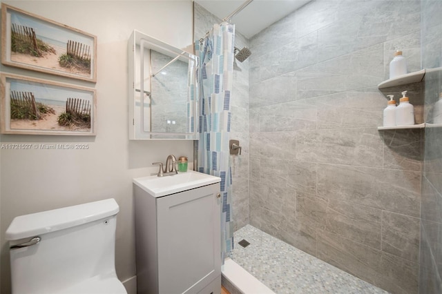 bathroom with toilet, a shower with shower curtain, and vanity