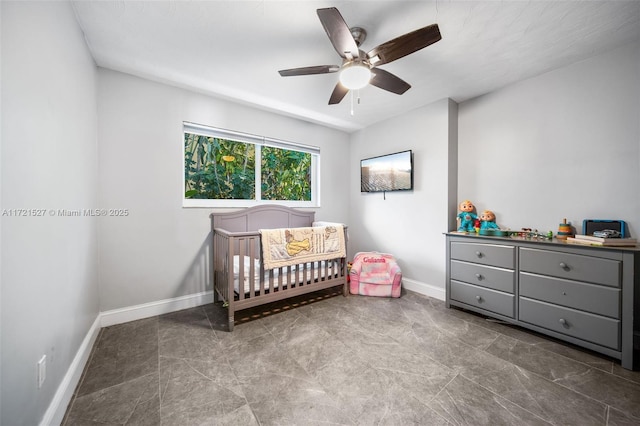 bedroom featuring a crib and ceiling fan