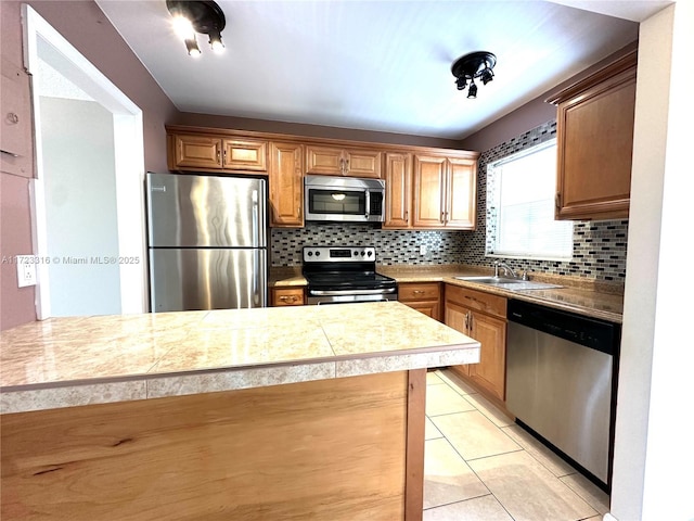 kitchen with decorative backsplash, light tile patterned flooring, sink, and appliances with stainless steel finishes