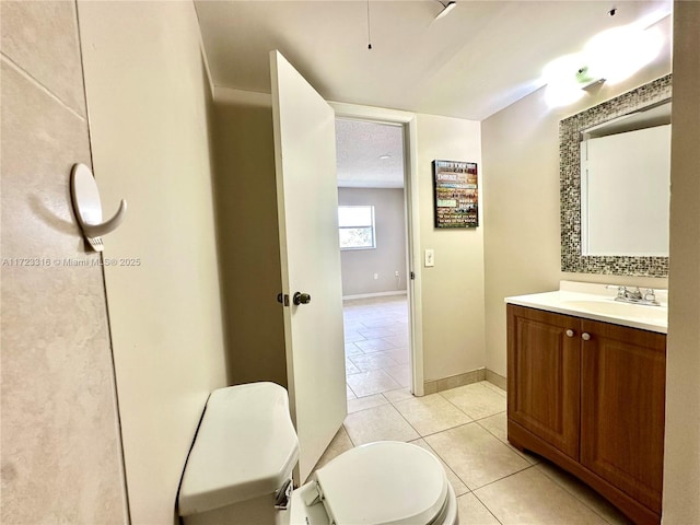 bathroom featuring tile patterned floors, vanity, and toilet