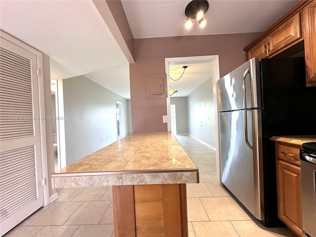 kitchen with stainless steel fridge and light tile patterned flooring