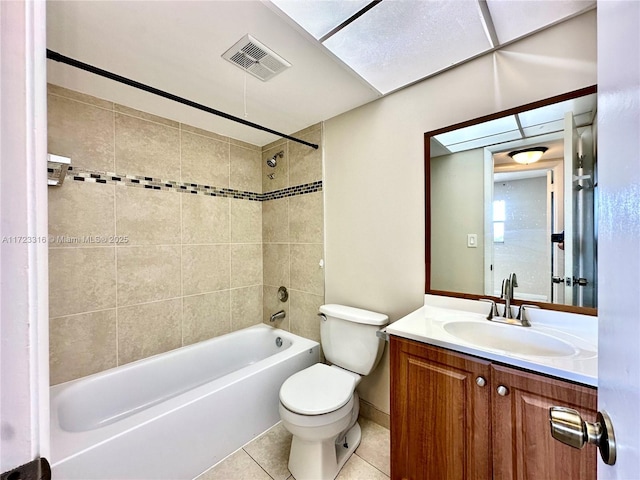 full bathroom with tile patterned flooring, vanity, tiled shower / bath combo, and toilet