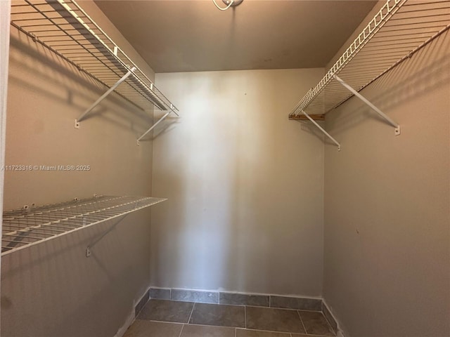 spacious closet with dark tile patterned floors