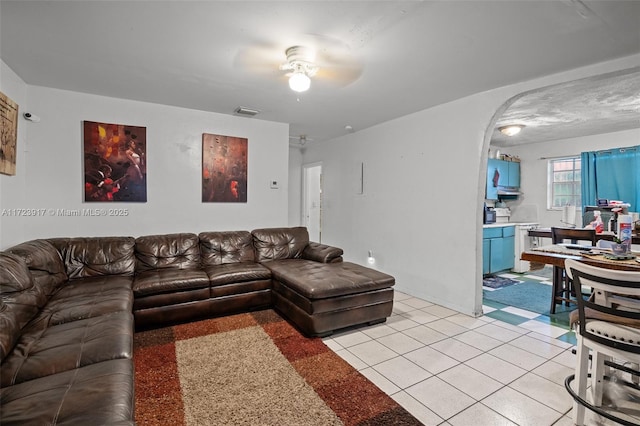 tiled living room with ceiling fan