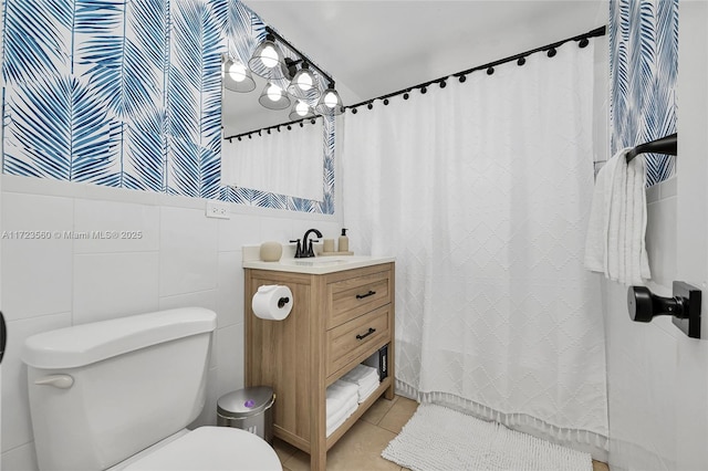 bathroom featuring tile patterned flooring, vanity, toilet, and tile walls