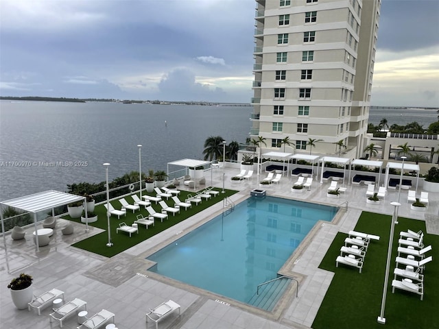 view of pool with a patio and a water view