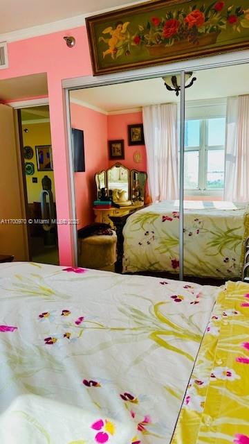 bedroom with a closet and ornamental molding