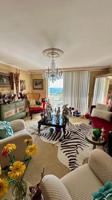 living room with carpet floors, ornamental molding, and a notable chandelier