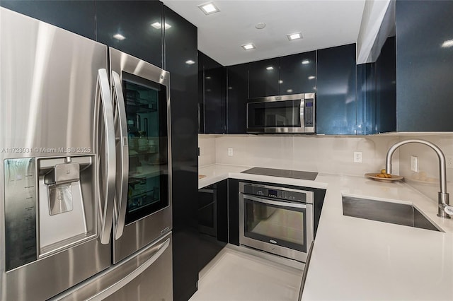 kitchen featuring stainless steel appliances, tasteful backsplash, and sink