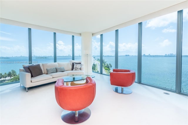 living room featuring floor to ceiling windows, a water view, and plenty of natural light