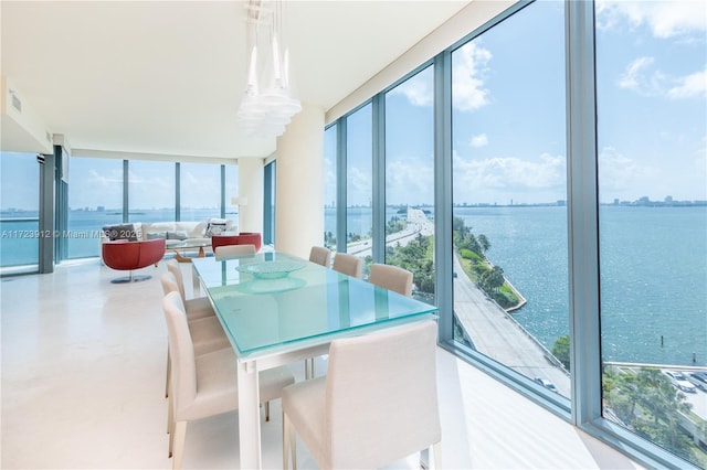 dining area featuring a wall of windows, a water view, and plenty of natural light