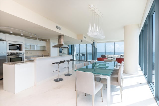 dining room with a wall of windows and a water view