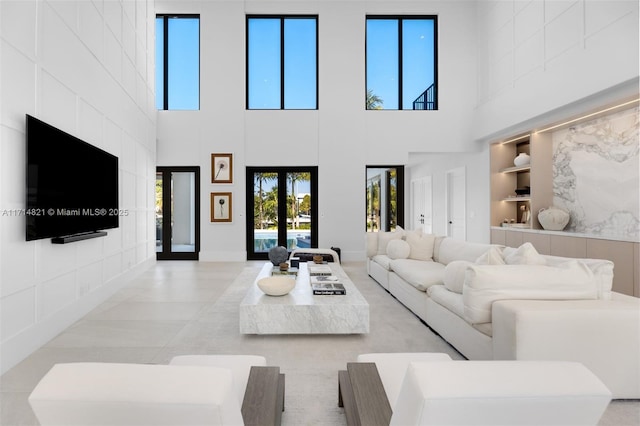 living room with french doors, plenty of natural light, and a high ceiling